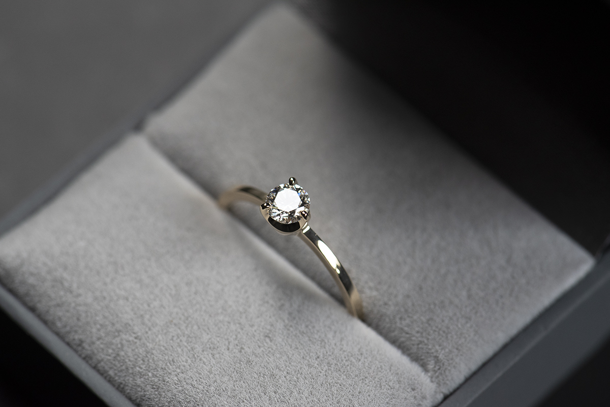 Prosty złoty pierścionek zaręczynowy z naturalnym lub laboratoryjnym 0,3 ct w szarym pudełku na biżuterię