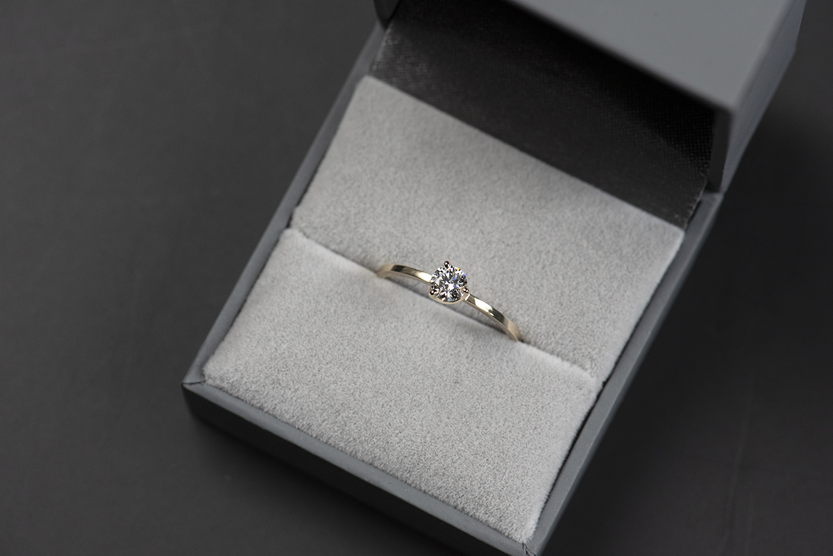 Prosty złoty pierścionek zaręczynowy z naturalnym lub laboratoryjnym 0,3 ct w szarym pudełku na biżuterię