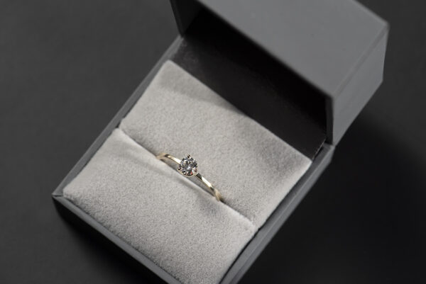 Prosty złoty pierścionek zaręczynowy z naturalnym lub laboratoryjnym 0,3 ct w szarym pudełku na biżuterię