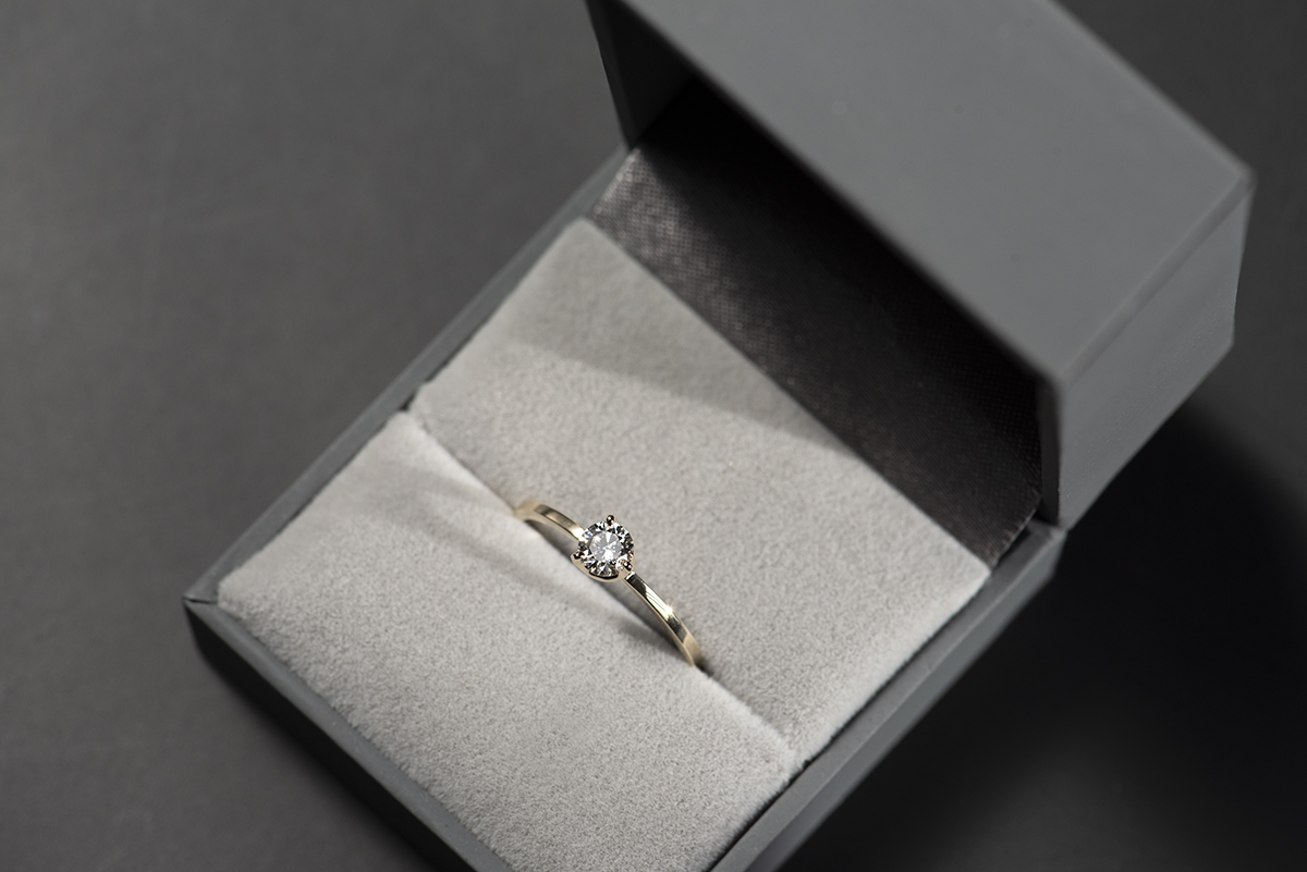 Prosty złoty pierścionek zaręczynowy z naturalnym lub laboratoryjnym 0,3 ct w szarym pudełku na biżuterię